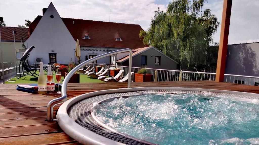 a hot tub sitting on a wooden deck with a deck at Kníže Ferdinand Apartments in Mikulov