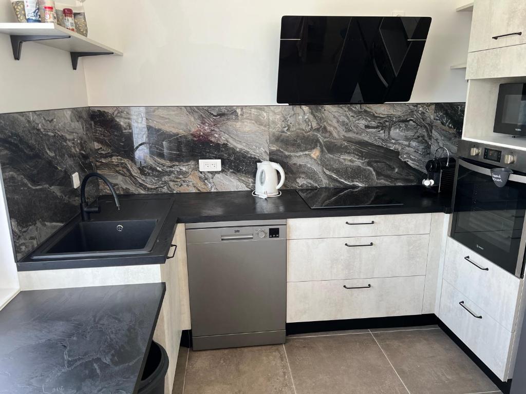 une cuisine avec un évier et un plan de travail dans l'établissement maison agréable et calme dans ile oleron, au Château-dʼOléron