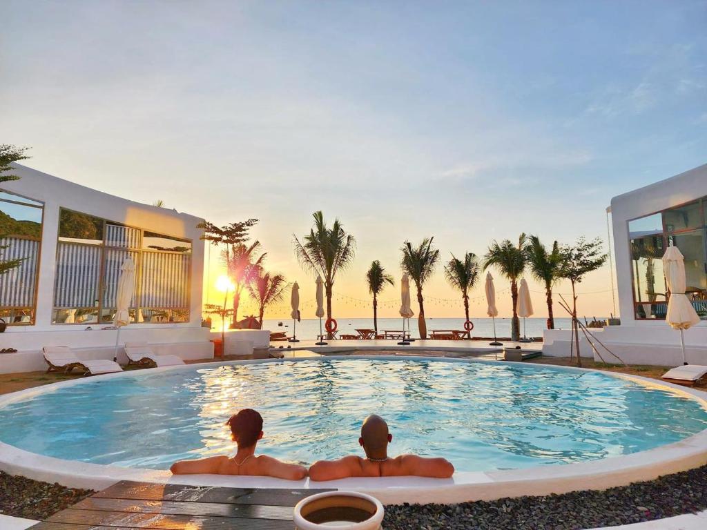 2 personnes assises dans une piscine d'un hôtel dans l'établissement iSea Resort, à Ba Ha