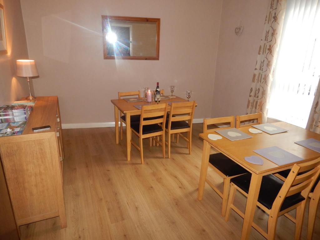 a dining room with a table and chairs and a mirror at Abercorn House in Derry Londonderry