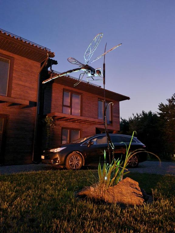 a car parked in a yard in front of a house at Vila DRAGONFLY in Šventoji