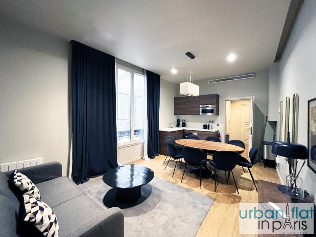 un salon avec un canapé et une table dans l'établissement Urban Flat 110 - Luxury 3 Bedroom near Galeries Lafayette, à Paris