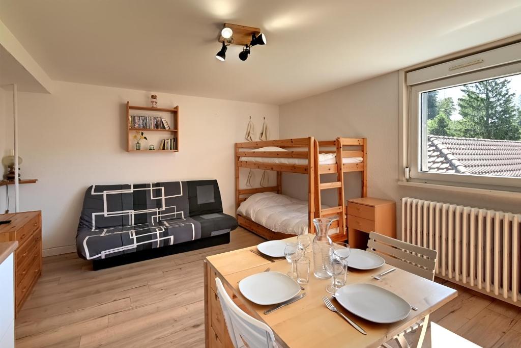 Cette chambre dispose d'une table à manger et de lits superposés. dans l'établissement Le Nid des Vosges - Appt vue montagne, à Gérardmer