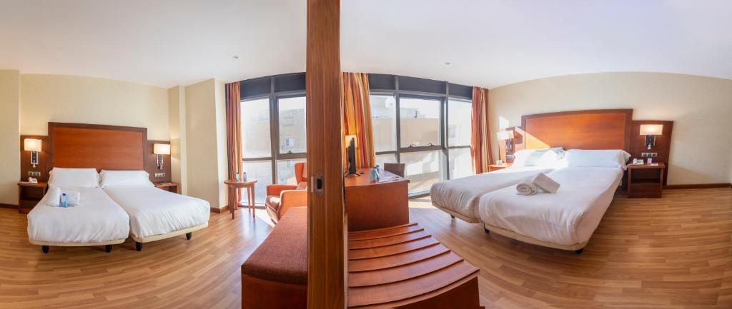 a hotel room with two beds and a balcony at Moon Dreams Calabahía in Cala del Moral