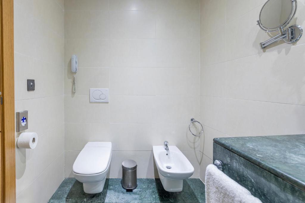 a white bathroom with a toilet and a sink at Moon Dreams Calabahía in Cala del Moral