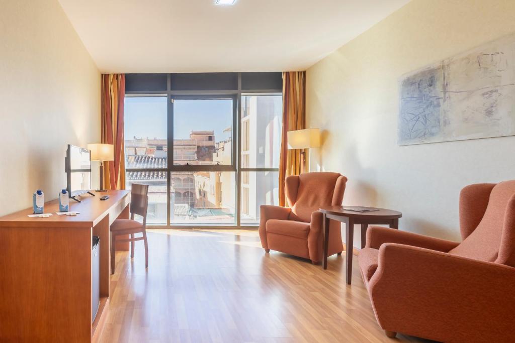 a room with chairs and a desk and a large window at Moon Dreams Calabahía in Cala del Moral