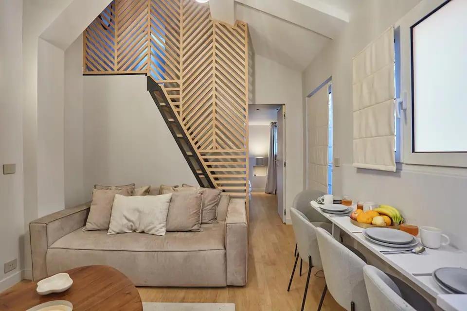 un salon avec un canapé et un escalier dans l'établissement Place de la Bastille Cozy and Modern 2BD, à Paris