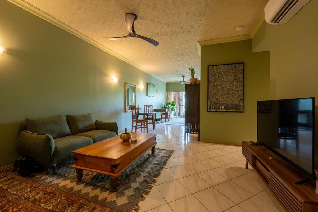 ein Wohnzimmer mit Sofa und Fernseher in der Unterkunft Lily Lakes - Resort Style Living in Cairns