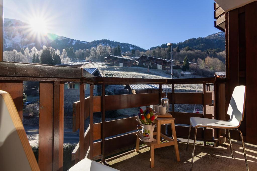 a balcony with a table and chairs and a view of a mountain at Résidence Le Prarion 24A ski in- ski out - Happy Rentals in Les Houches