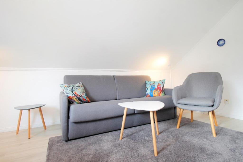 ein Wohnzimmer mit einer Couch und einem Tisch und einem Stuhl in der Unterkunft Haus Barbara - Schwimmbad und Sauna im Haus - Whg 3 in Grömitz