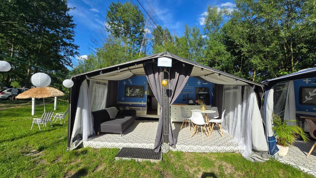 a gazebo with a couch and chairs in a yard at Camperowe Swawole - Bondi in Bielawa