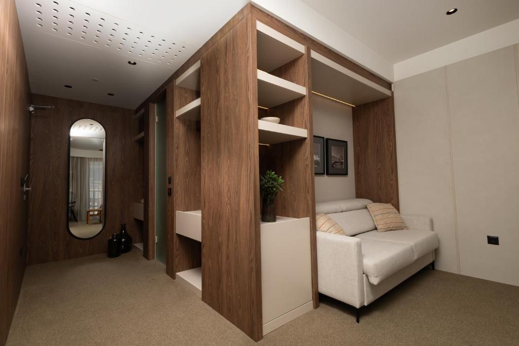 a living room with a couch and a mirror at Infinity Hotel & More in Budva