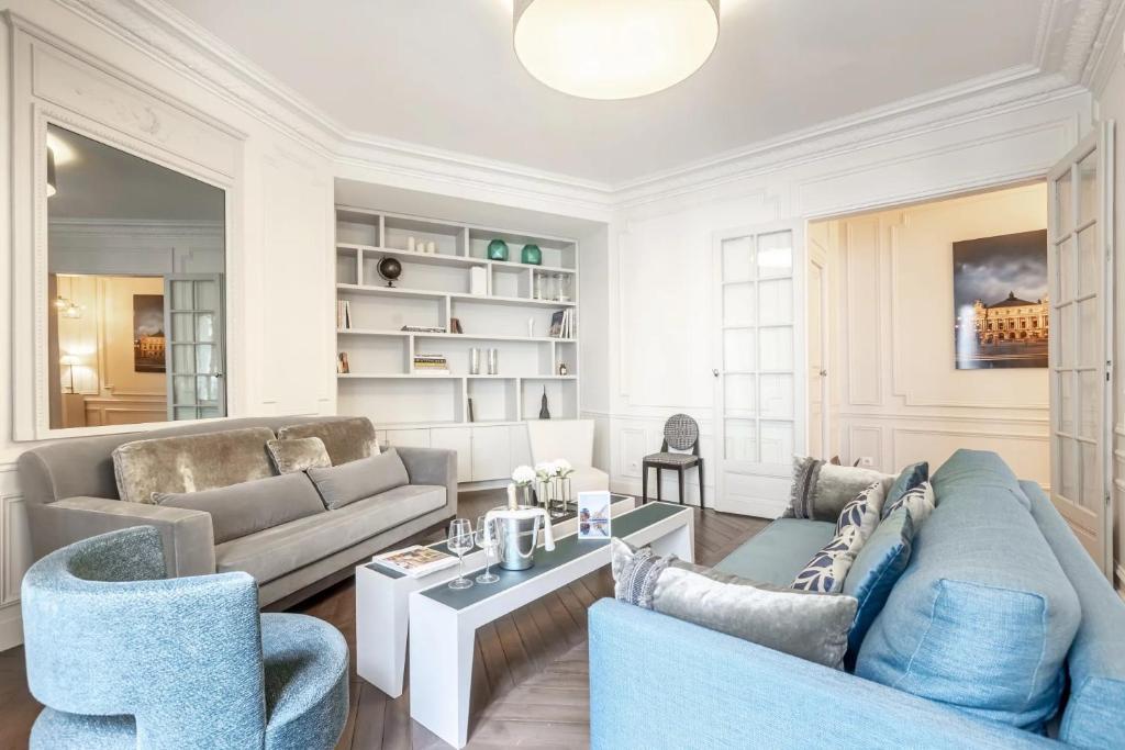 un salon avec un canapé, des chaises et une table dans l'établissement Sublime Appartement de Charme, à Paris