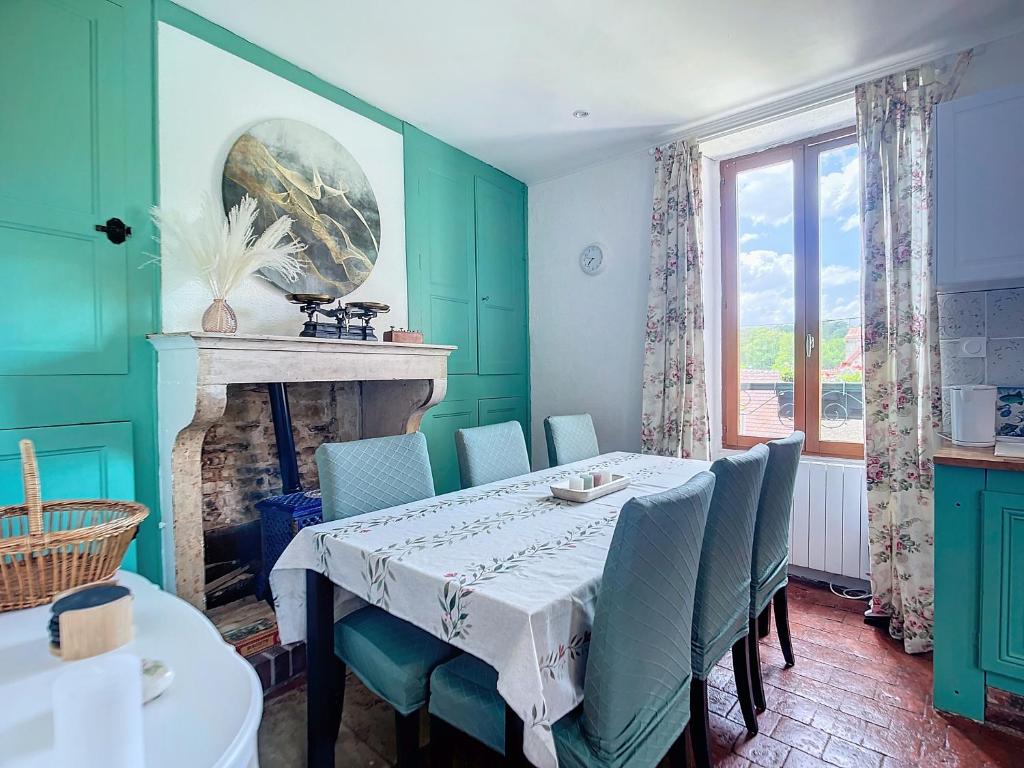 ein Esszimmer mit Tisch und Kamin in der Unterkunft Charmante maison in Joux-la-Ville