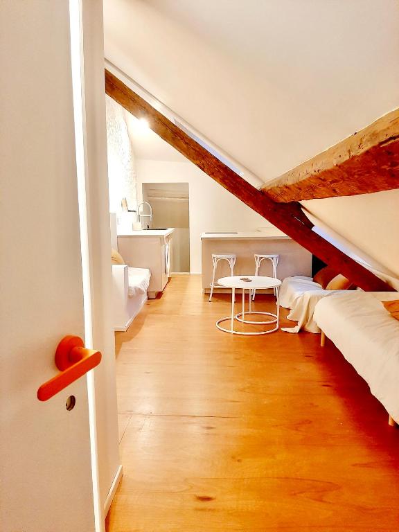 Cette chambre mansardée comprend un lit et un bureau. dans l'établissement Charmant studio rue piétonne, à Thonon-les-Bains