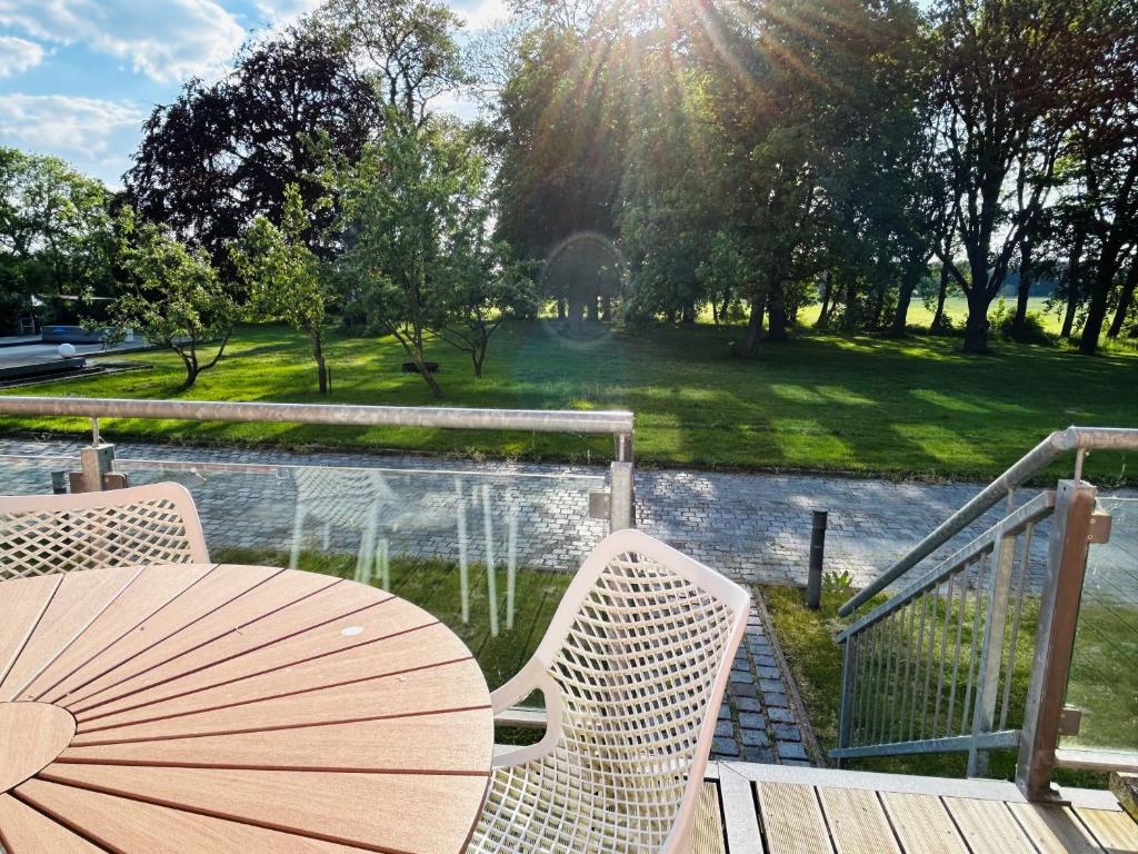 a table and chairs with an umbrella on a deck at Gutshaus Wohnung 1 in Laschendorf