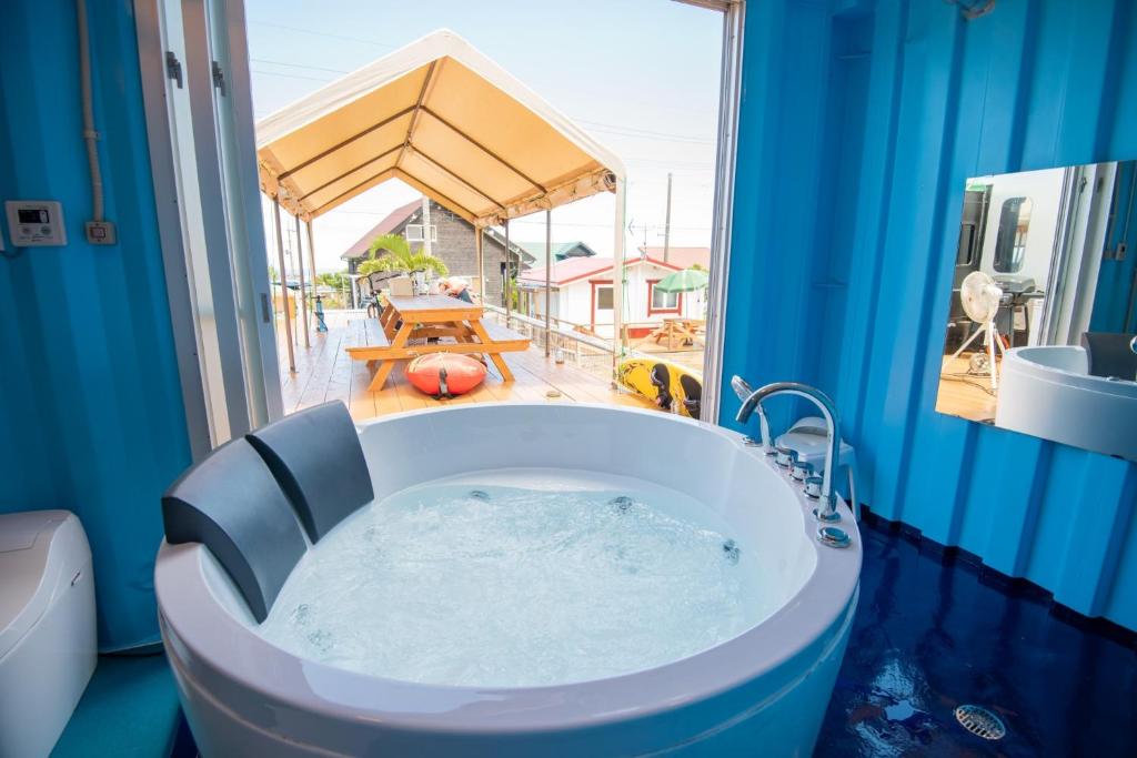 a bath tub in a bathroom with a view of a patio at Private Villa 405 - Vacation STAY 66258v in Shushi