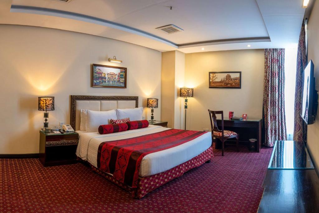 a hotel room with a bed and a desk at Ramada by Wyndham Islamabad in Islamabad