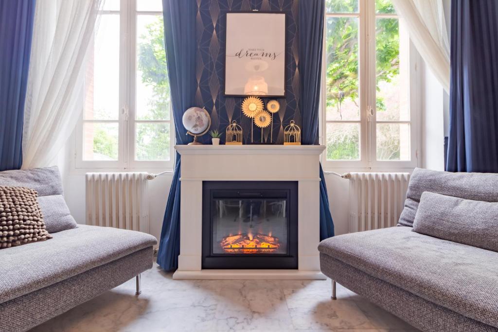 - un salon avec une cheminée et 2 chaises dans l'établissement Belle maison familiale avec piscine privée, à Lézat-sur-Lèze