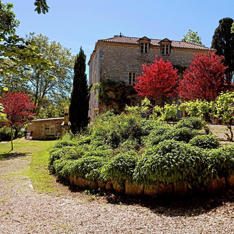un vieux bâtiment en briques avec des buissons devant lui dans l'établissement STUDIO chez La Maison Forte, à Montaut