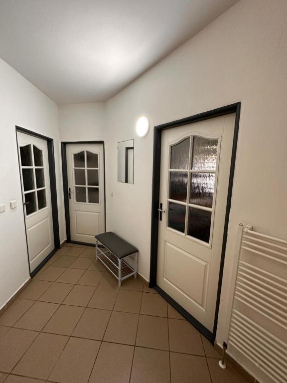 a room with three doors and a tiled floor at Apartmán Chlupáč in Harrachov