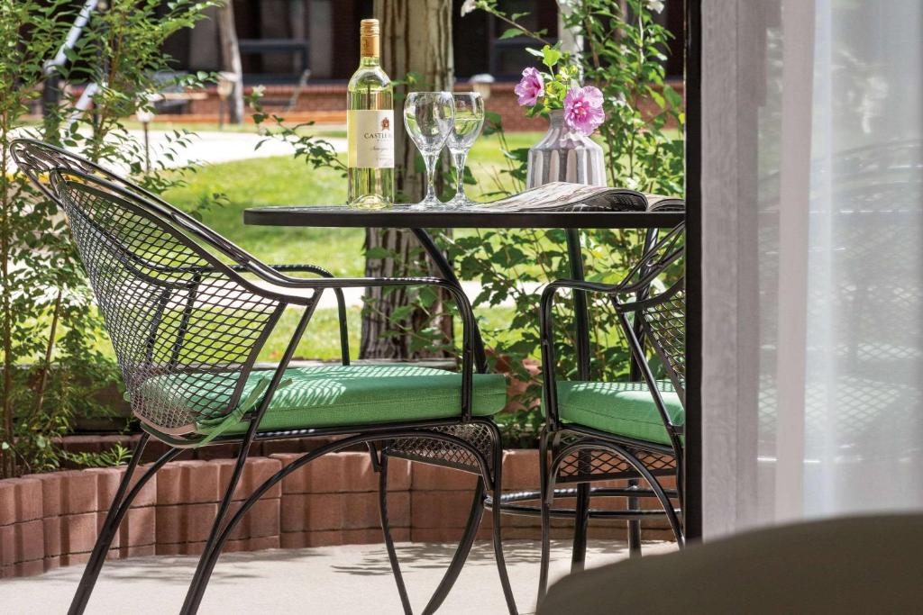 a table with two chairs and two bottles of wine at Radisson Hotel Colorado Springs Airport in Colorado Springs
