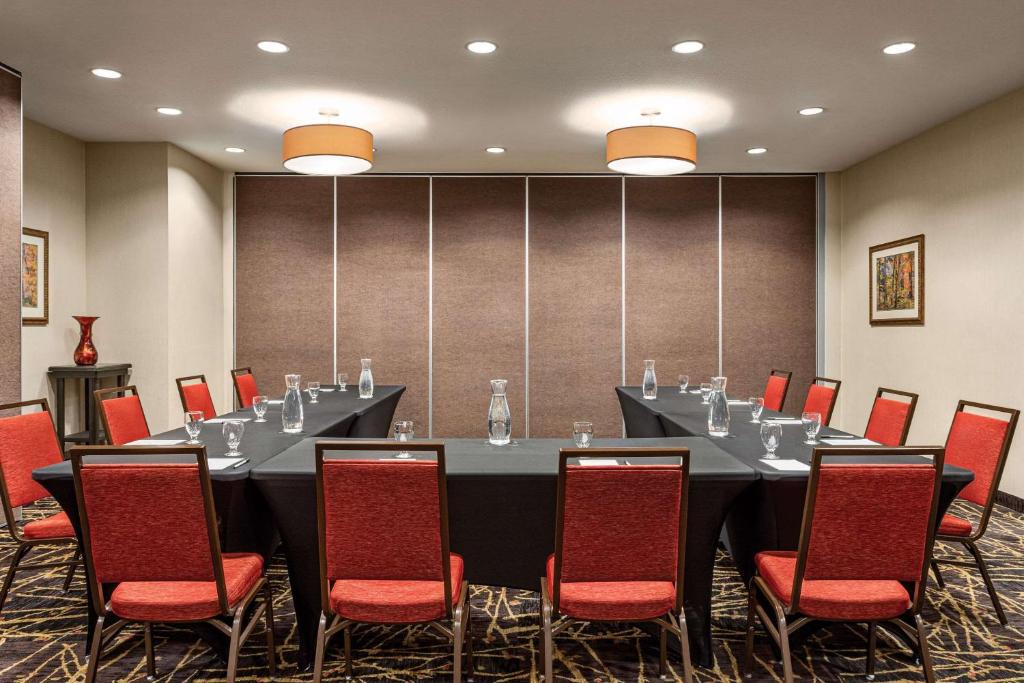 a conference room with a long table and red chairs at Radisson Hotel Colorado Springs Airport in Colorado Springs