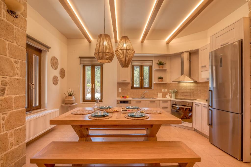 una cucina con un tavolo di legno e un frigorifero di Edem Stone Villa a Kíssamos