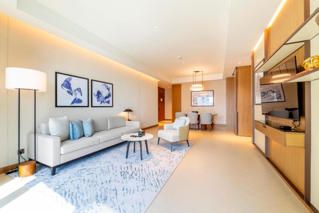 een woonkamer met een bank en een tafel bij Luxe 3-BR in Address Dubai Opera with Full Burj View in Dubai