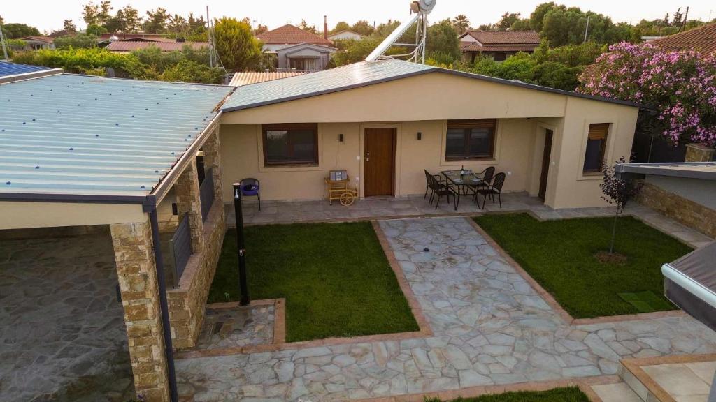 a small house with a patio and a yard at Victoria's Apartments in Nea Plagia
