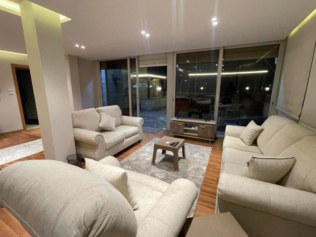 a living room with two white couches and a table at شقة بروف خارجي in Cairo