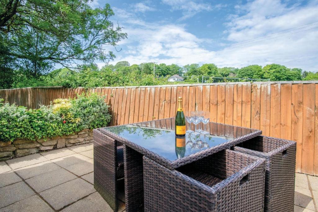 - une bouteille de vin assise sur une table sur une terrasse dans l'établissement Clover Cottage - 2 Bedroom Cottage - Begelly, à Saundersfoot