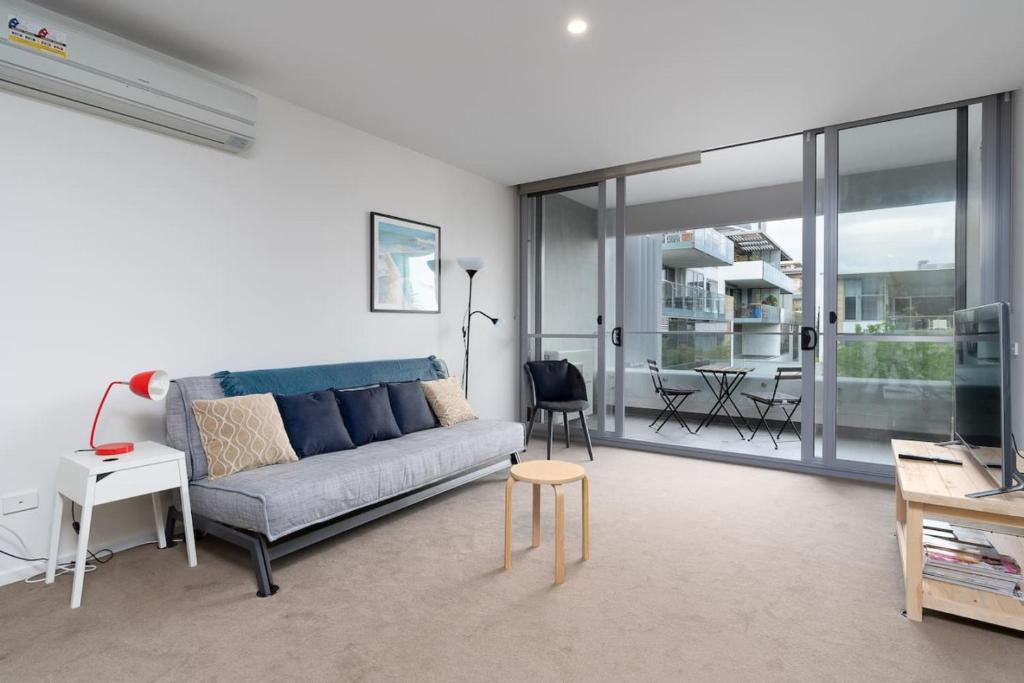 een woonkamer met een bank en een tafel bij Kingston Foreshore with Garden View - Hosted by Canstay in Kingston 