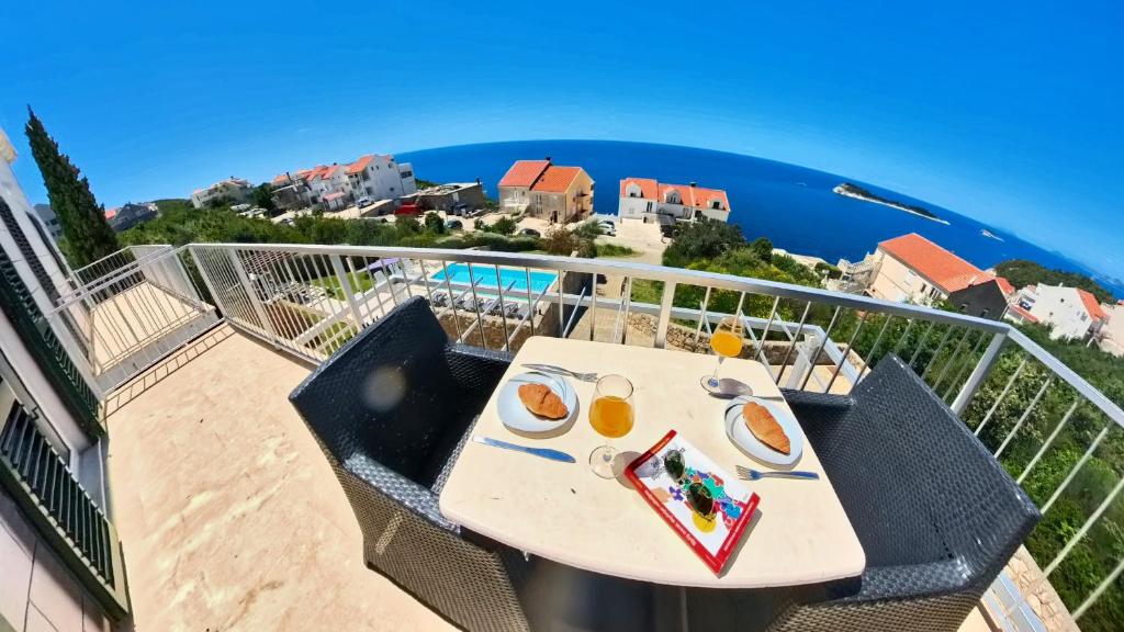 a table on a balcony with a view of the ocean at Villa Apartments Mecajac in Cavtat