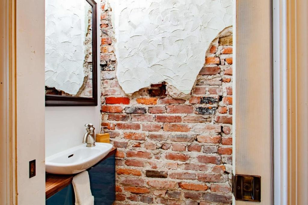 a bathroom with a brick wall and a sink at Inviting 3-Lvl DC Townhome Walk to METRO Station & Union Market H Street NoMa Union Station in Washington, D.C.