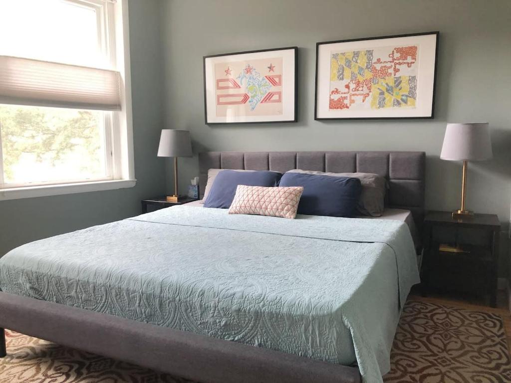 a bedroom with a bed with blue sheets and two windows at Inviting 3-Lvl DC Townhome Walk to METRO Station & Union Market H Street NoMa Union Station in Washington, D.C.