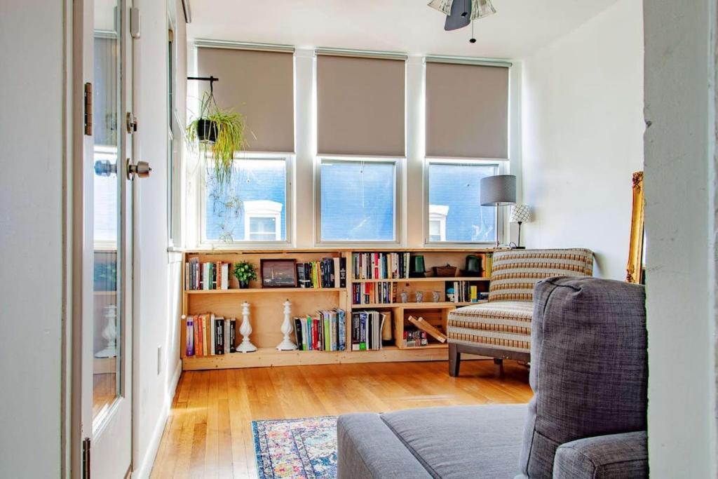 a living room with a couch and a book shelf with books at Inviting 3-Lvl DC Townhome Walk to METRO Station & Union Market H Street NoMa Union Station in Washington, D.C.