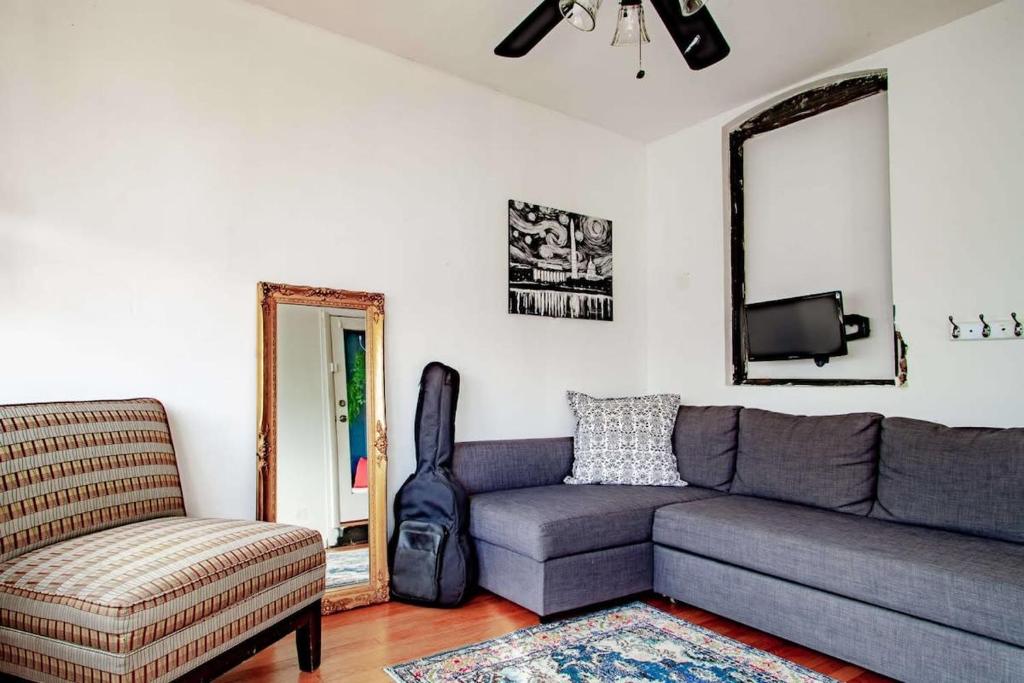 a living room with a couch and a chair at Inviting 3-Lvl DC Townhome Walk to METRO Station & Union Market H Street NoMa Union Station in Washington, D.C.