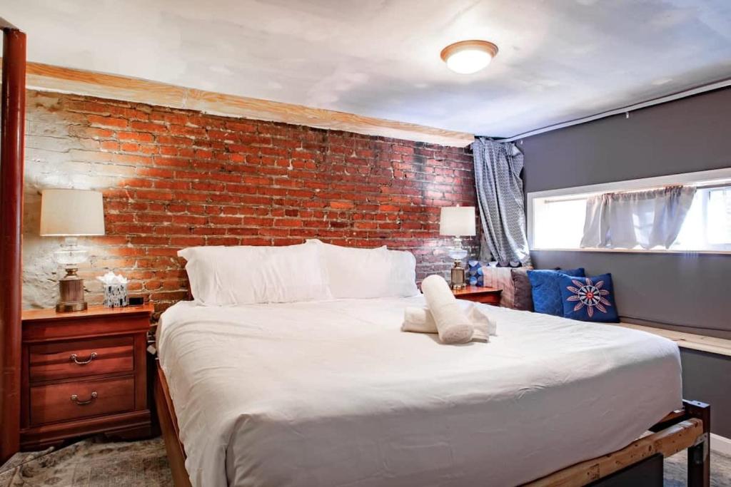 a bedroom with a large bed with a brick wall at Inviting 3-Lvl DC Townhome Walk to METRO Station & Union Market H Street NoMa Union Station in Washington, D.C.