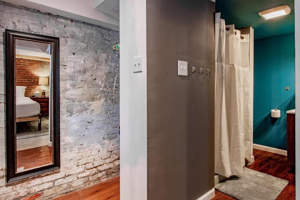 a bathroom with a mirror and a brick wall at Inviting 3-Lvl DC Townhome Walk to METRO Station & Union Market H Street NoMa Union Station in Washington, D.C.