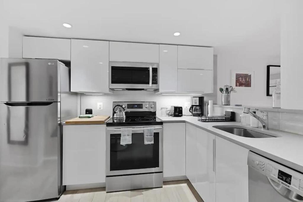 a kitchen with white cabinets and a stove top oven at Heart Of Dupont and Walk to Georgetown in Washington, D.C.