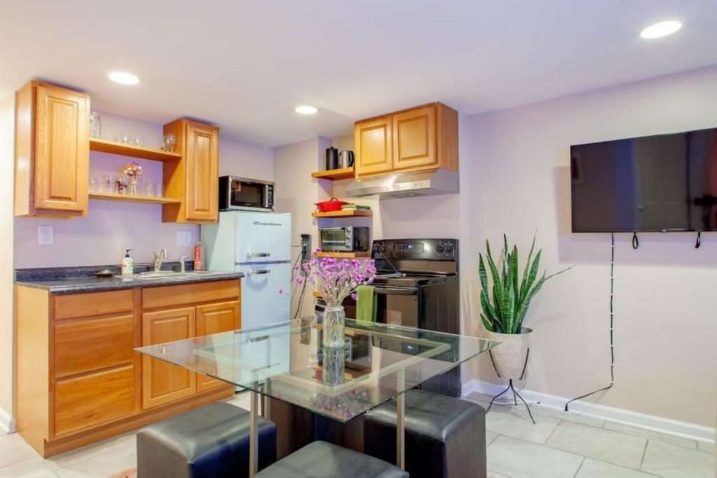 a kitchen with a glass table and a refrigerator at 2-BR City Retreat Peace Privacy & Parking in Washington, D.C.