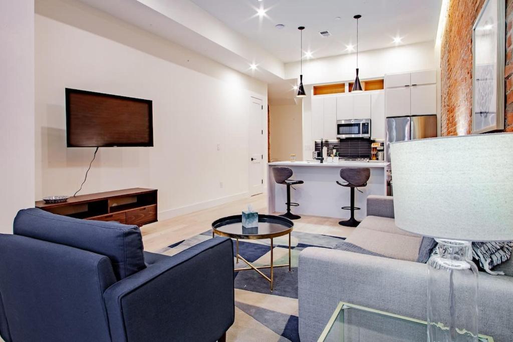 a living room with a couch and a table at Vibrant 2-BR Luxe Flat Adjacent Eastern Market Walk to METRO Barracks Row Capitol Hill in Washington, D.C.