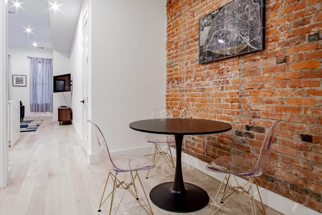 a table and chairs in a room with a brick wall at Vibrant 2-BR Luxe Flat Adjacent Eastern Market Walk to METRO Barracks Row Capitol Hill in Washington, D.C.