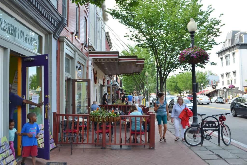 a group of people walking down a sidewalk near a cafe at Vibrant 2-BR Luxe Flat Adjacent Eastern Market Walk to METRO Barracks Row Capitol Hill in Washington, D.C.