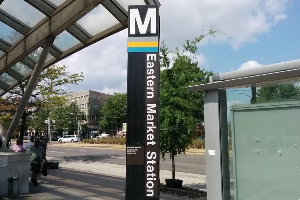 a pole with a sign for a bus stop at Eastern Market & METRO Accessible Modern Charm Walk Everywhere in Washington, D.C.