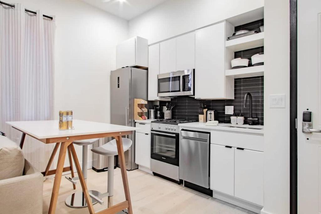 a kitchen with white cabinets and a wooden table at Eastern Market & METRO Accessible Modern Charm Walk Everywhere in Washington, D.C.