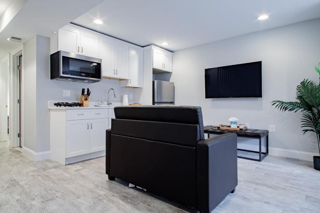 a kitchen with white cabinets and a black chair at Central DC Flat Sleeps 3 Convention Center in Washington, D.C.