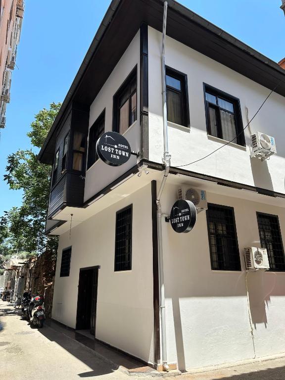 a white building with signs on the side of it at Loost Town Inn Hotel in Antalya