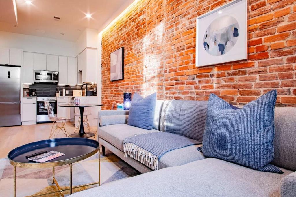 a living room with a couch and a brick wall at Barracks Row & Eastern Market Oasis Transit-Friendly in Washington, D.C.